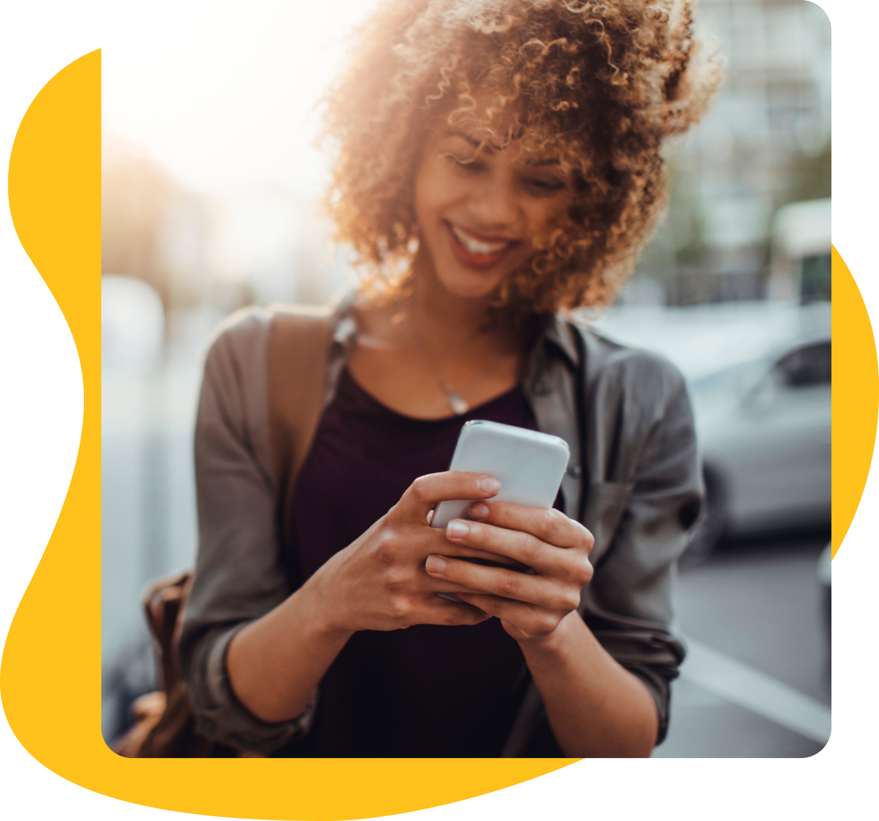 Imagem de uma mulher olhando para o celular e sorrindo