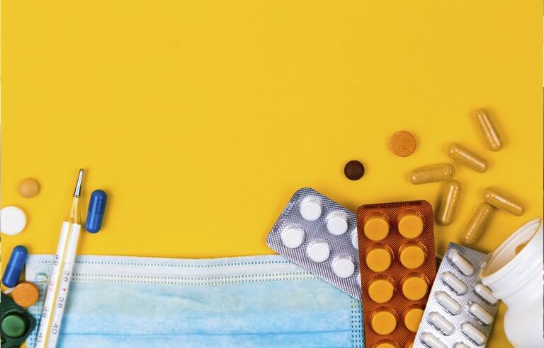 Diversos medicamentos espalhados em uma superfície amarela