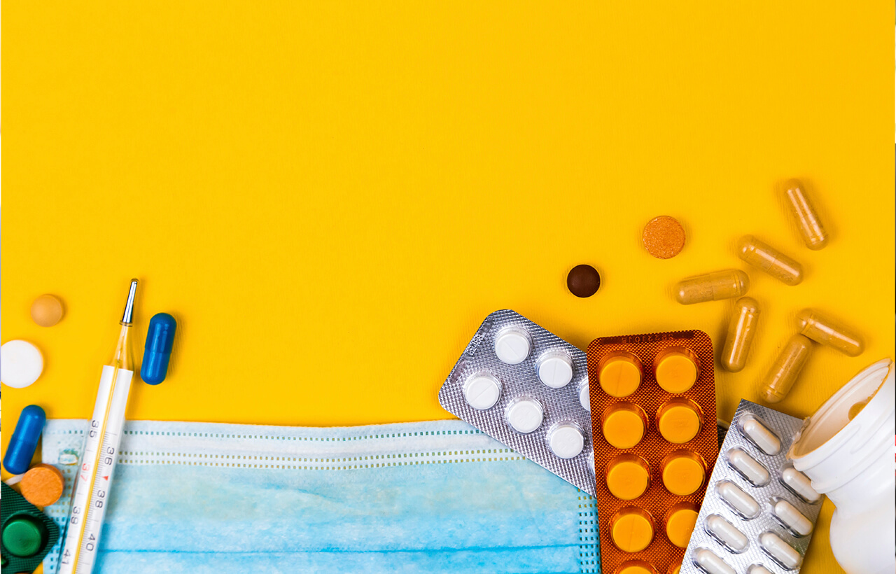 Diversos medicamentos espalhados em uma superfície amarela