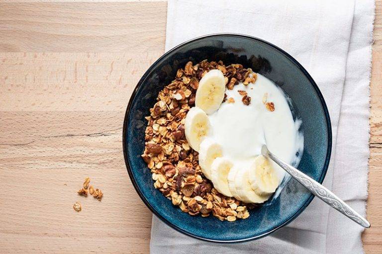 Um tijela de granola com banana e iogurte